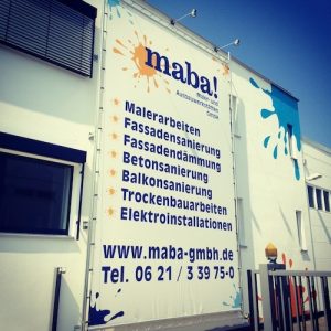 Montage von einem Banner-Lift an einer Fassade in Mannheim. Das Banner wurde von uns produziert und im Rahmen gespannt.